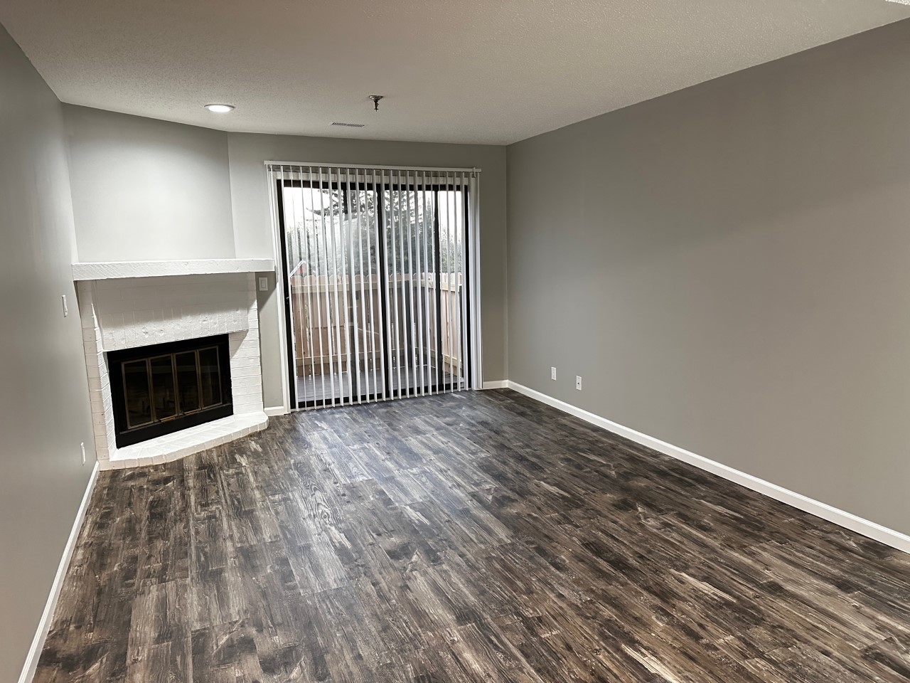 1340 Brook Street, Unit J St. Charles, IL 60174 - Photo 4 of 11 an empty room with wooden floor and fireplace