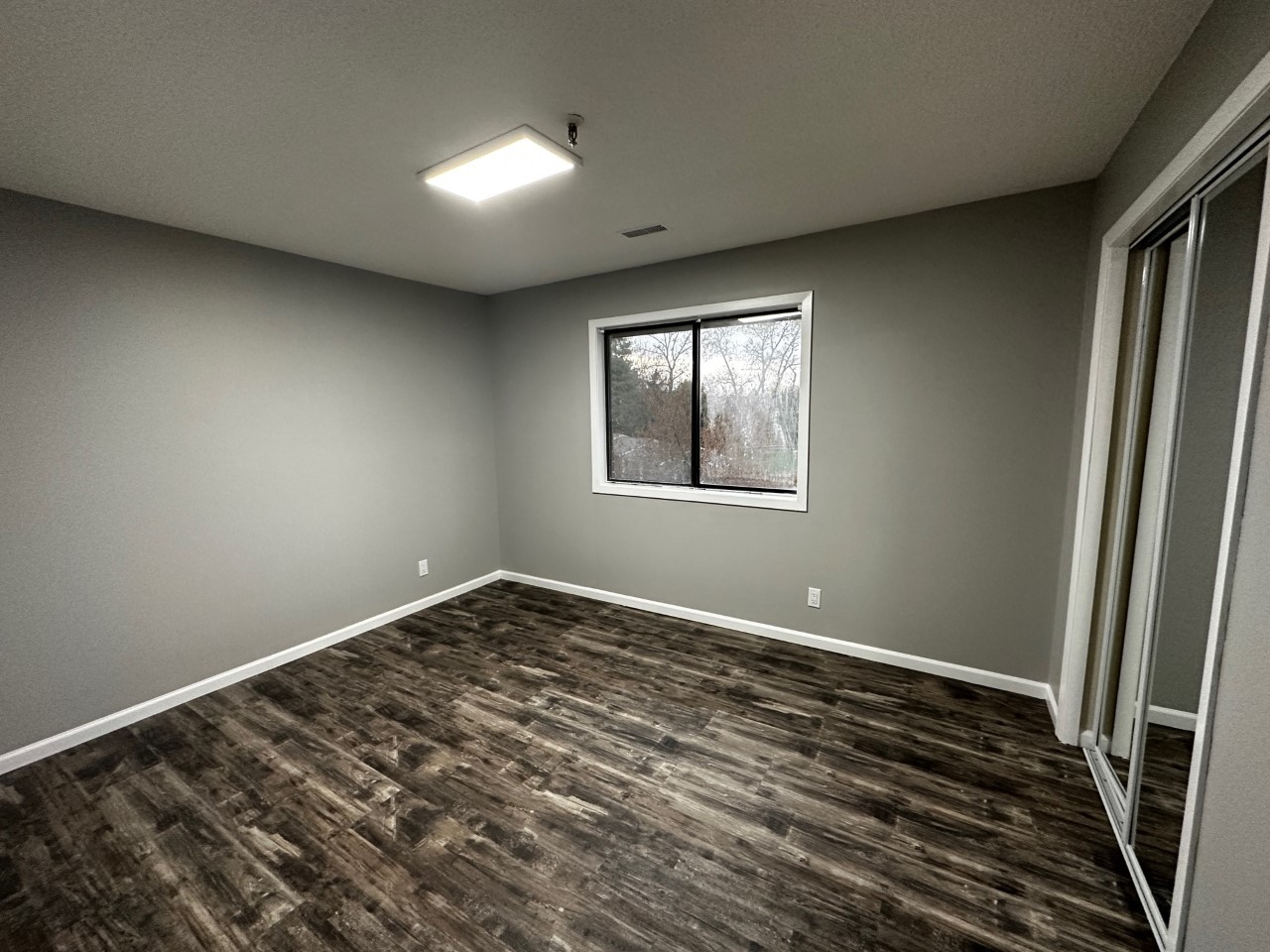 1340 Brook Street, Unit J St. Charles, IL 60174 - Photo 5 of 11 a view of an empty room with wooden floor and a window