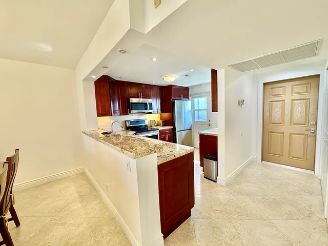 a kitchen with stainless steel appliances granite countertop a stove top oven a sink dishwasher and a refrigerator