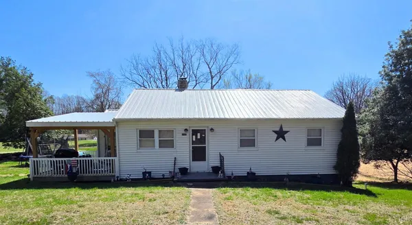 a view of a house with a backyard and wooden fence