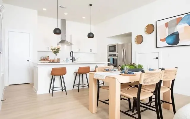 a kitchen with stainless steel appliances kitchen island granite countertop a table and chairs