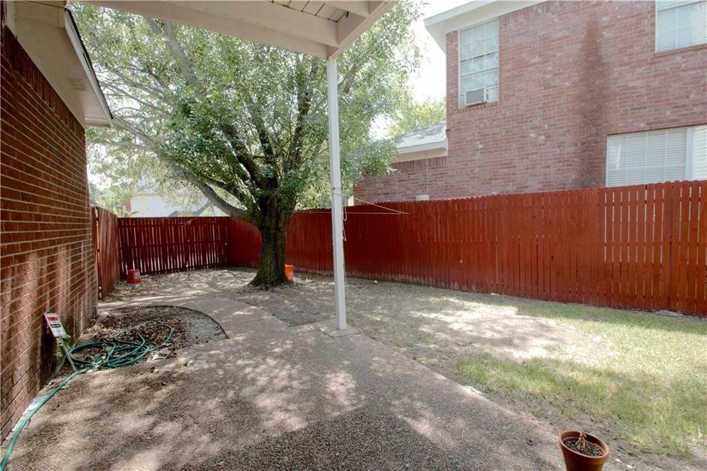 559 Raintree Circle Coppell, TX 75019 - Photo 13 of 18 a view of a backyard with large trees and wooden fence