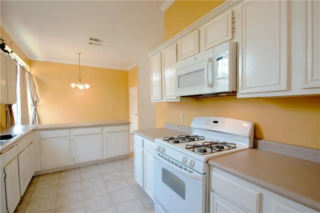559 Raintree Circle Coppell, TX 75019 - Photo 9 of 18 a kitchen with granite countertop cabinets and white appliances