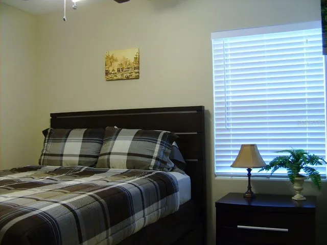 a bedroom with a bed and a potted plant