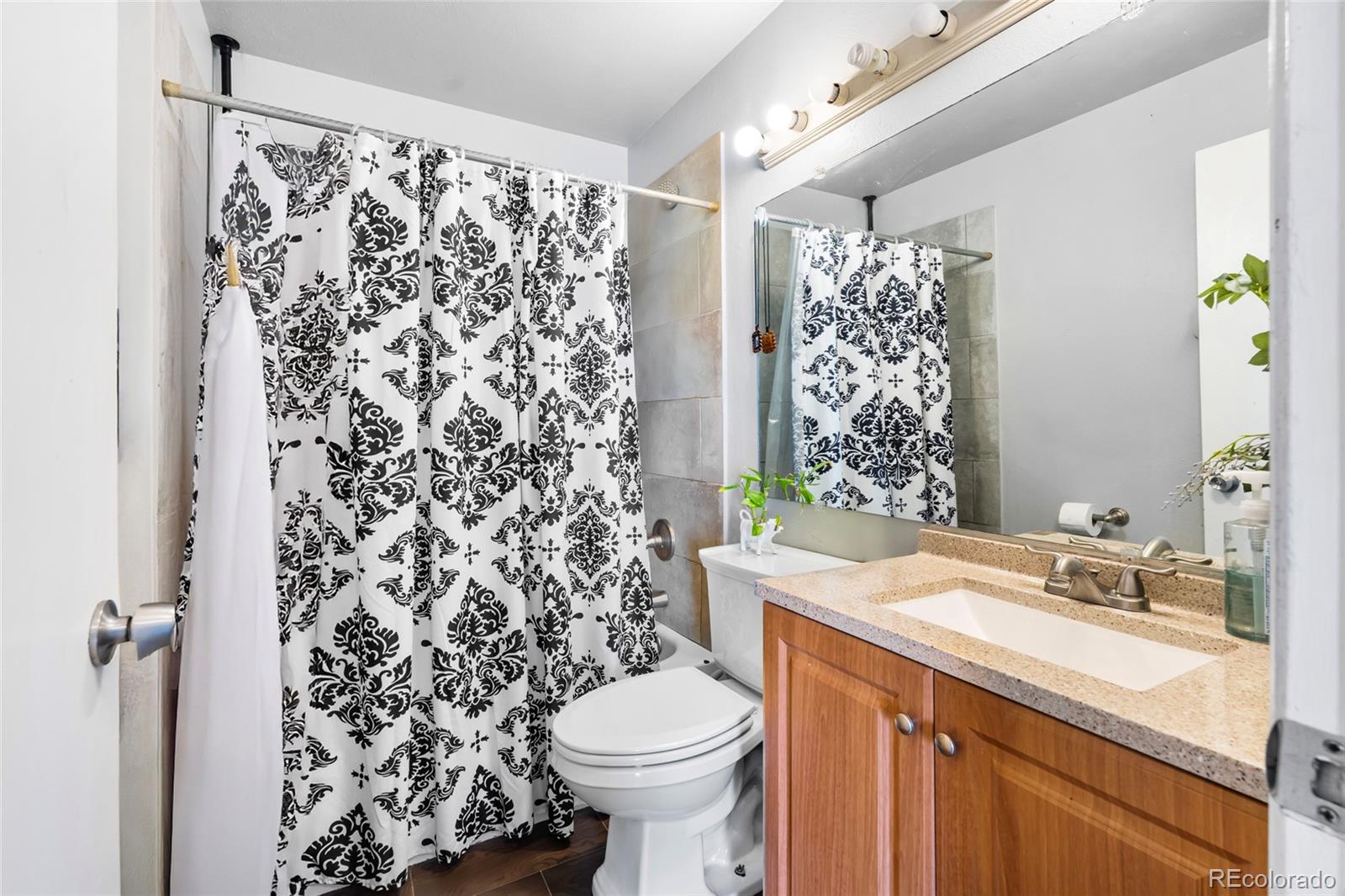 4609 Fontana Way Denver, CO 80239 - Photo 12 of 22 a bathroom with a sink toilet and shower