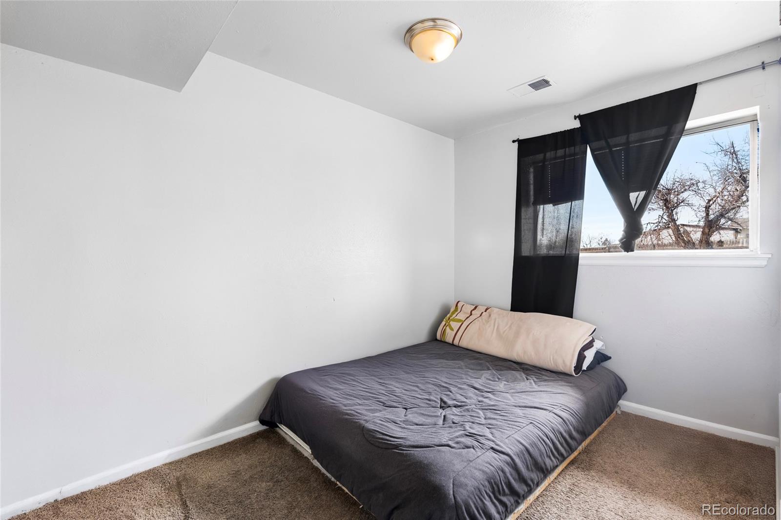 4609 Fontana Way Denver, CO 80239 - Photo 15 of 22 a bedroom with a bed and a window