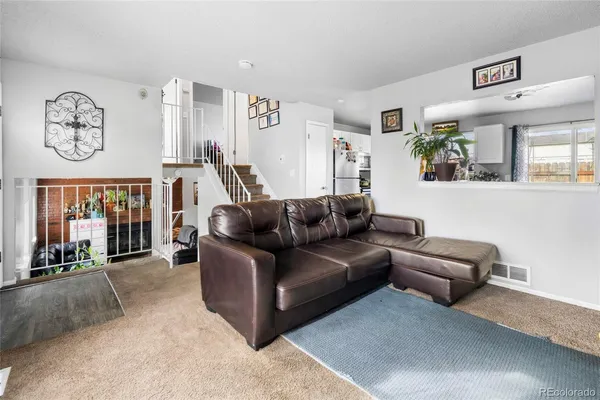a living room with furniture a rug and a window