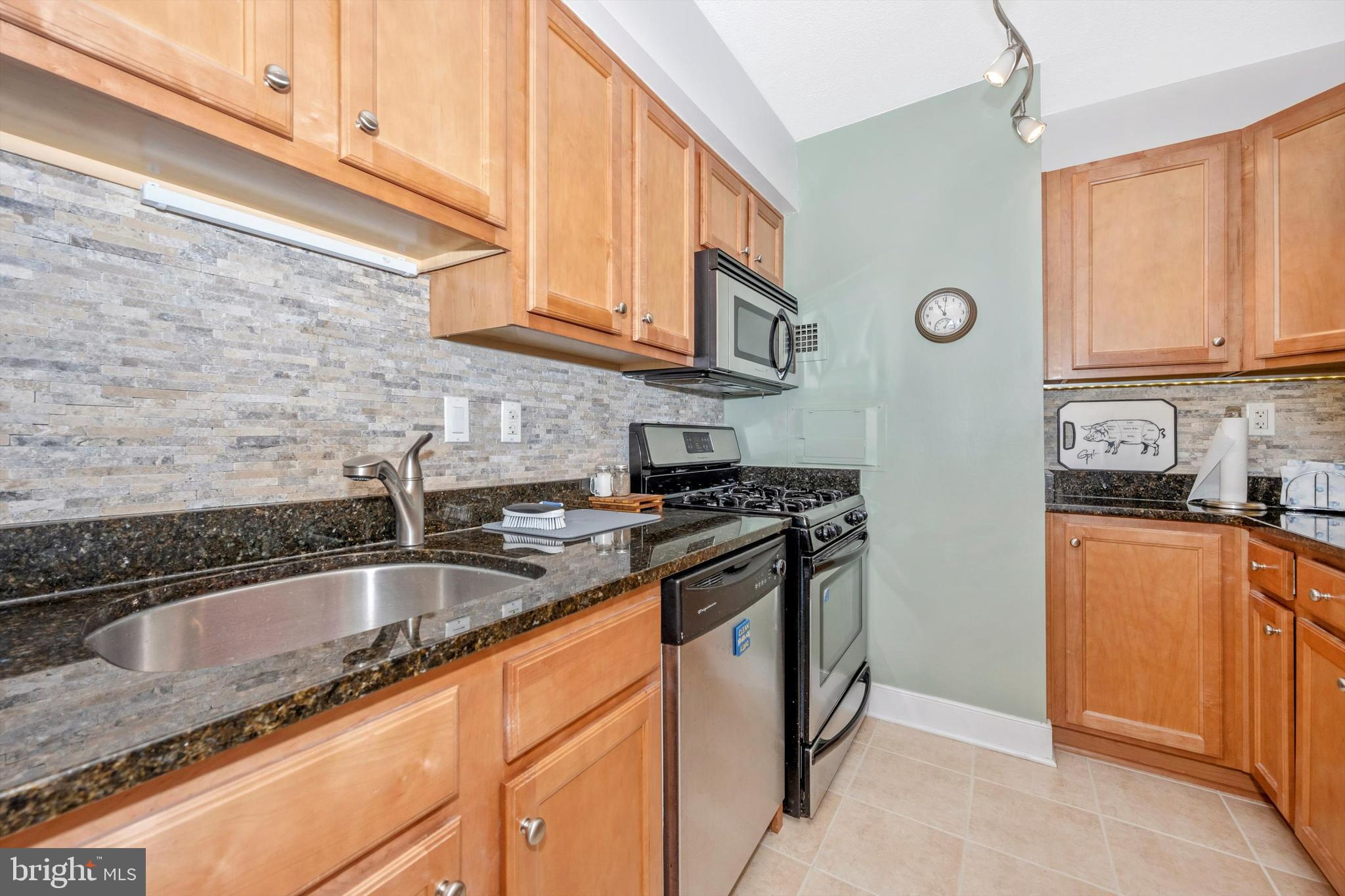 a kitchen with stainless steel appliances granite countertop a sink stove and cabinets
