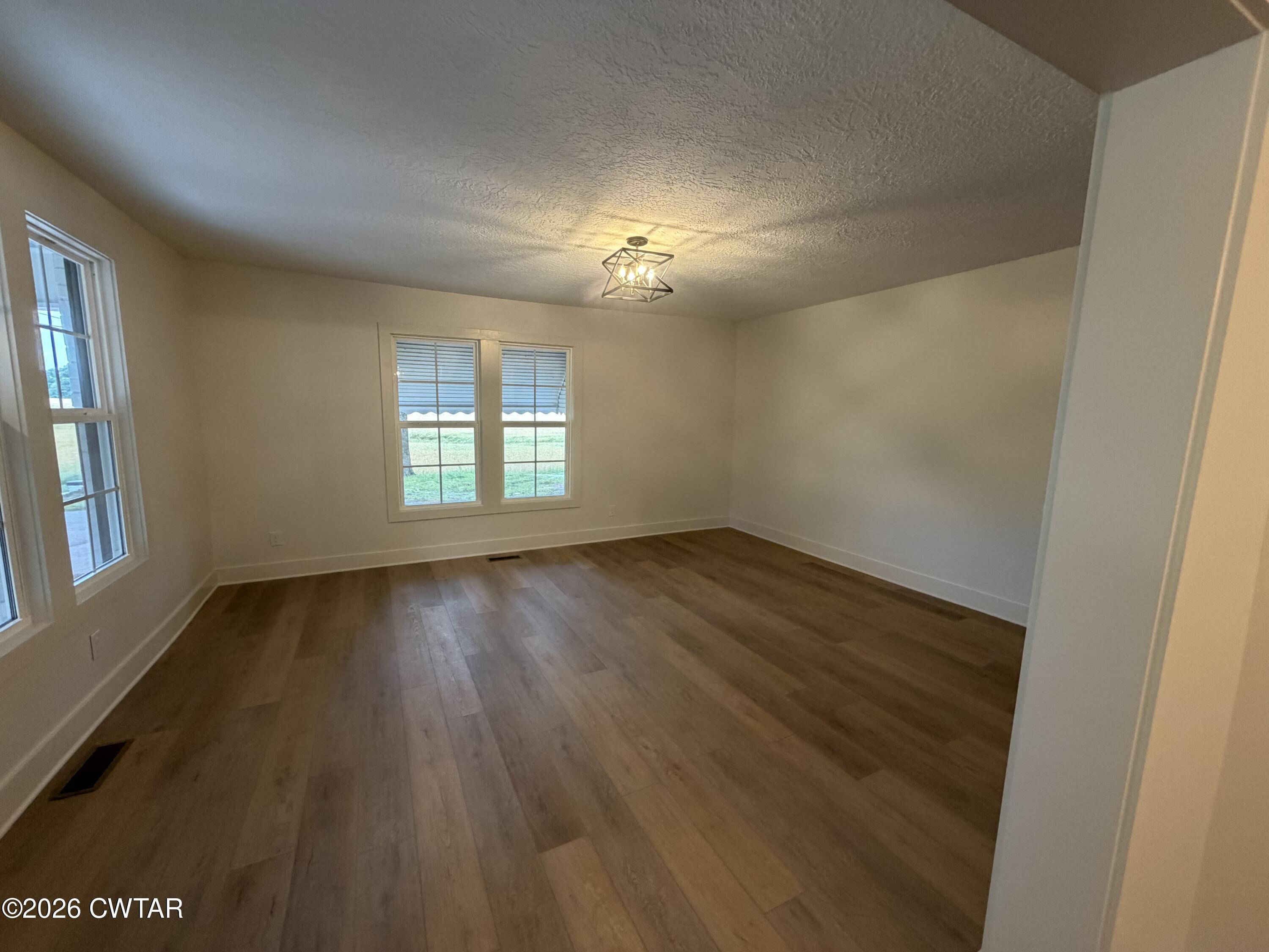 16 Manner Frank Road Milan, TN 38358 - Photo 5 of 25 an empty room with wooden floor and windows