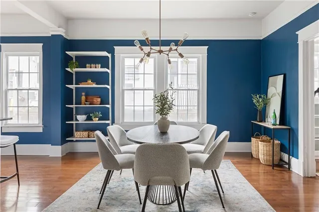 a dining room with furniture a chandelier and wooden floor