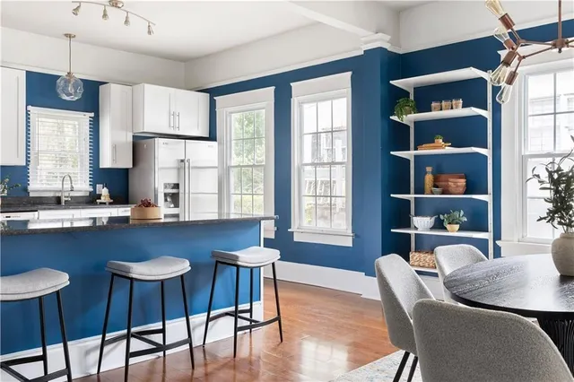 a kitchen with granite countertop a dining table chairs workspace and a window