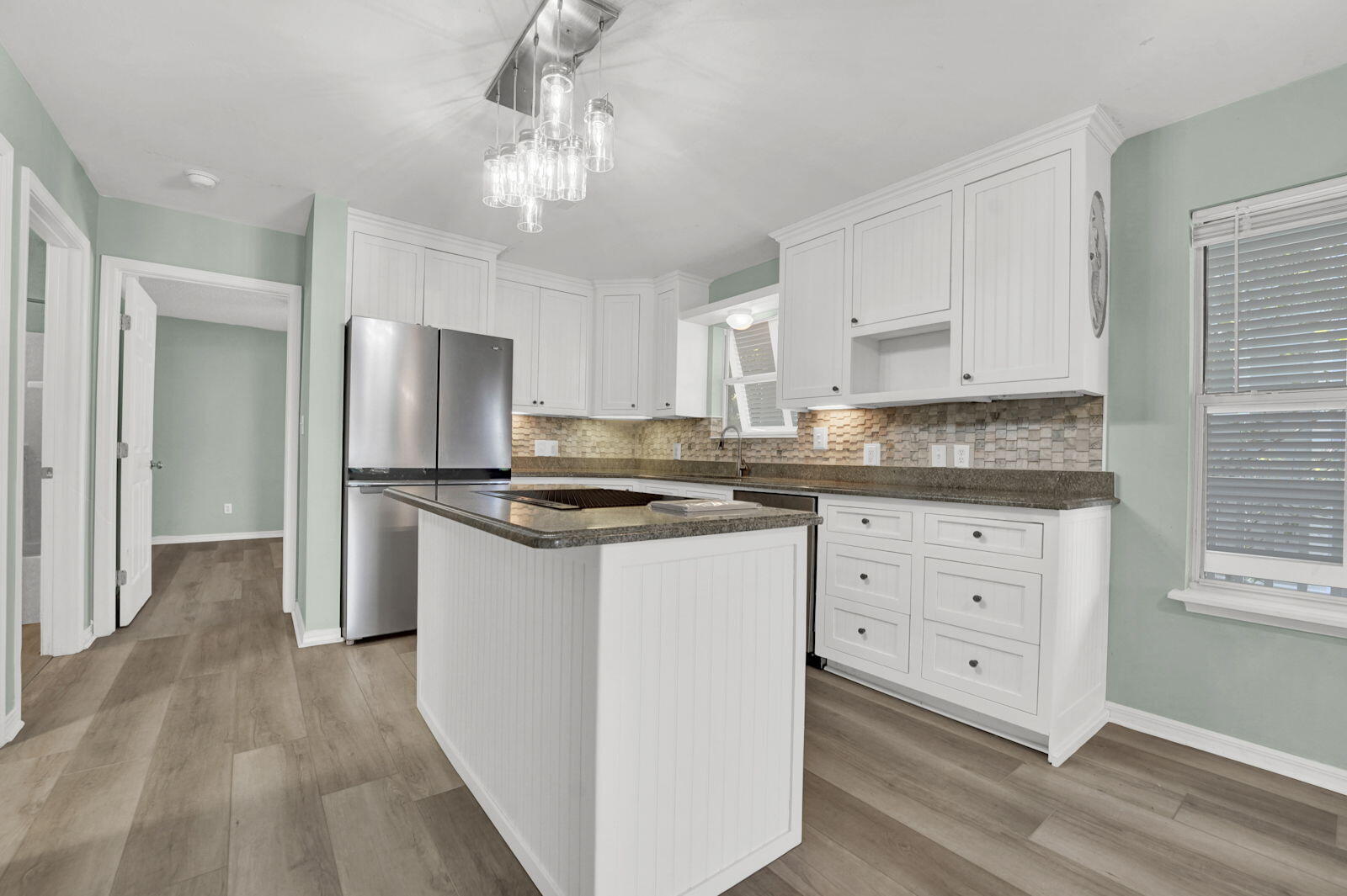 93 Beachfront Trail Santa Rosa Beach, FL 32459 - Photo 10 of 42 a kitchen with stainless steel appliances granite countertop a refrigerator a sink dishwasher a stove and white cabinets with wooden floor