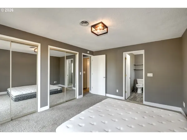 a bedroom with a bed and a large mirror