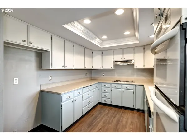 a kitchen with granite countertop white cabinets and white appliances