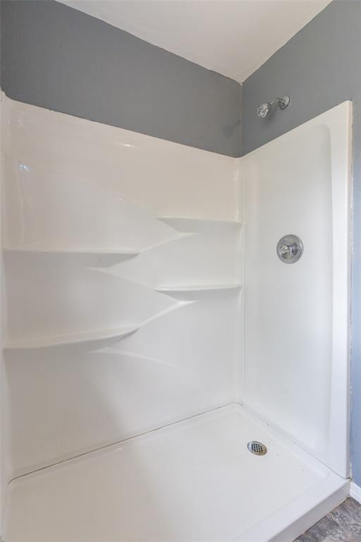 2841 Old Anson Road Abilene, TX 79603 - Photo 12 of 34 The property features a shower with a white surround and integrated shelving