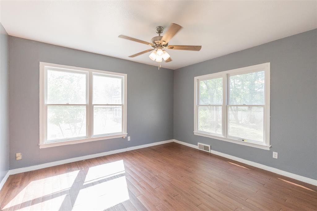 2841 Old Anson Road Abilene, TX 79603 - Photo 13 of 34 Living space featuring wood flooring, a ceiling fan with light fixture, and two large windows providing natural light