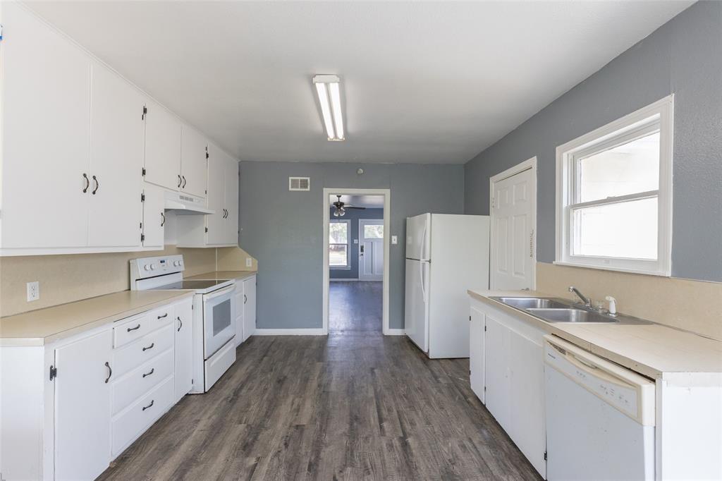 2841 Old Anson Road Abilene, TX 79603 - Photo 18 of 34 The kitchen features extensive white cabinetry, light-colored countertops, and durable wood-look flooring