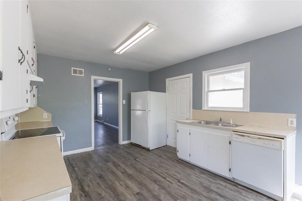 2841 Old Anson Road Abilene, TX 79603 - Photo 19 of 34 The kitchen features white cabinetry, a double basin sink, and a dishwasher