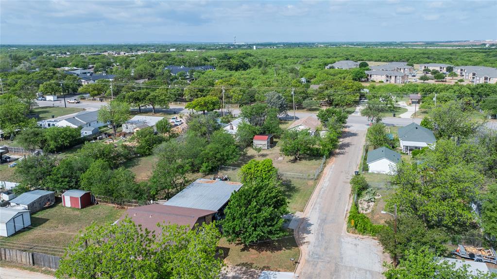 2841 Old Anson Road Abilene, TX 79603 - Photo 20 of 34 The property is situated in a neighborhood characterized by abundant mature trees and residential structures, with a paved road visible