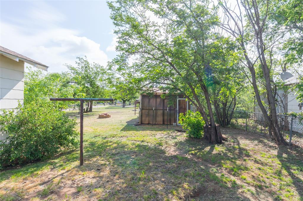 2841 Old Anson Road Abilene, TX 79603 - Photo 28 of 34 The property features a spacious backyard with a lawn, mature trees, and a storage shed