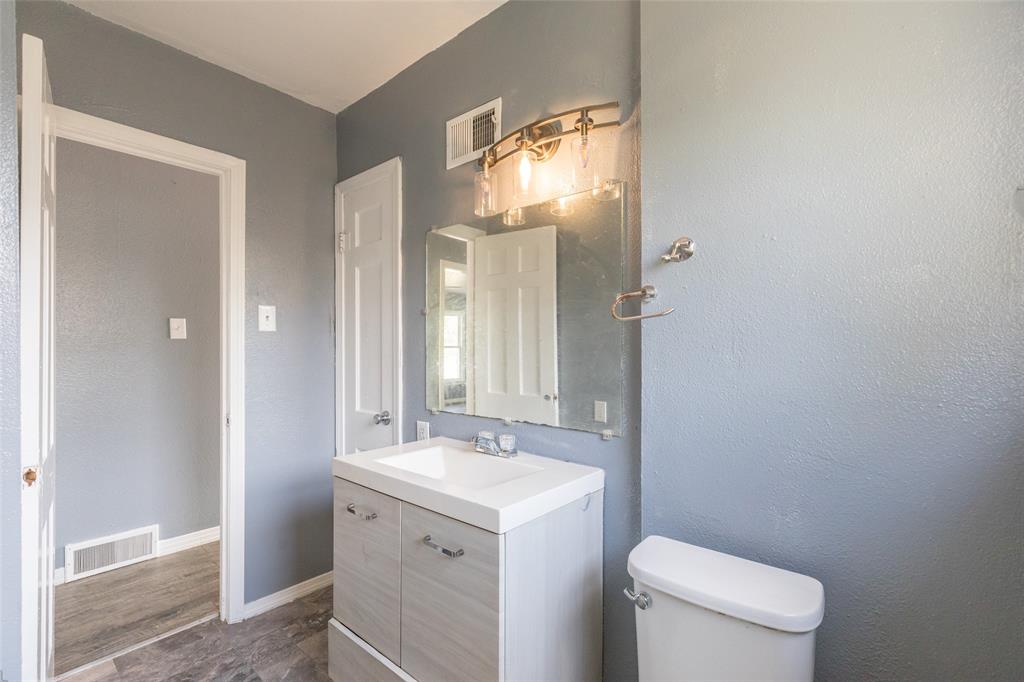 2841 Old Anson Road Abilene, TX 79603 - Photo 10 of 34 Bathroom featuring a vanity with a white rectangular sink, a wall-mounted mirror, and a light fixture with glass shades