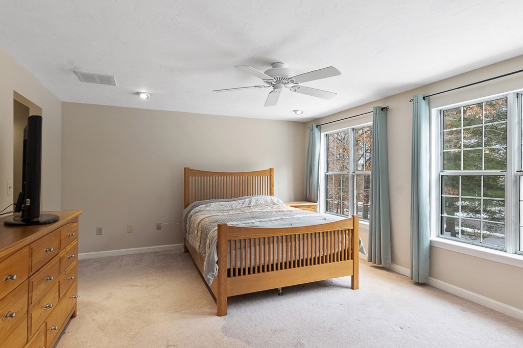 512 Ridgefield Circle, Unit C Clinton, MA 01510 - Photo 13 of 28 a bedroom with a bed and a flat tv screen on a dresser