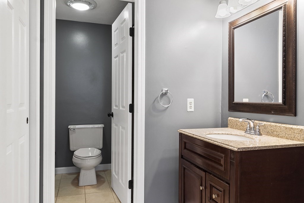 512 Ridgefield Circle, Unit C Clinton, MA 01510 - Photo 16 of 28 a bathroom with a toilet a sink and mirror