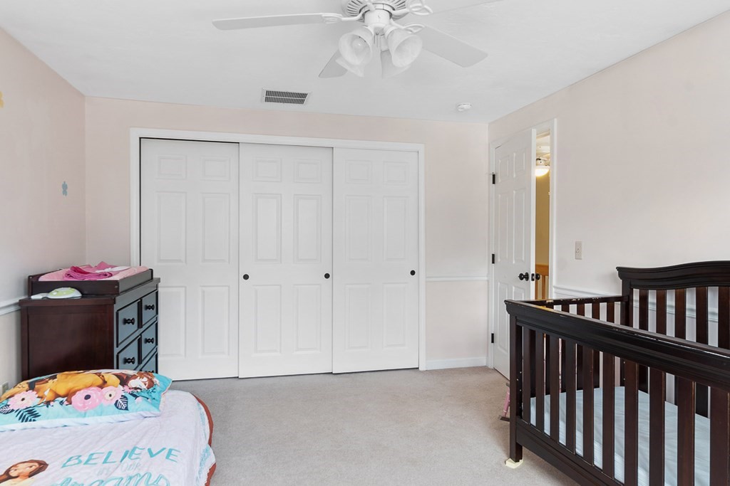 512 Ridgefield Circle, Unit C Clinton, MA 01510 - Photo 20 of 28 a bedroom with a bed and a chandelier