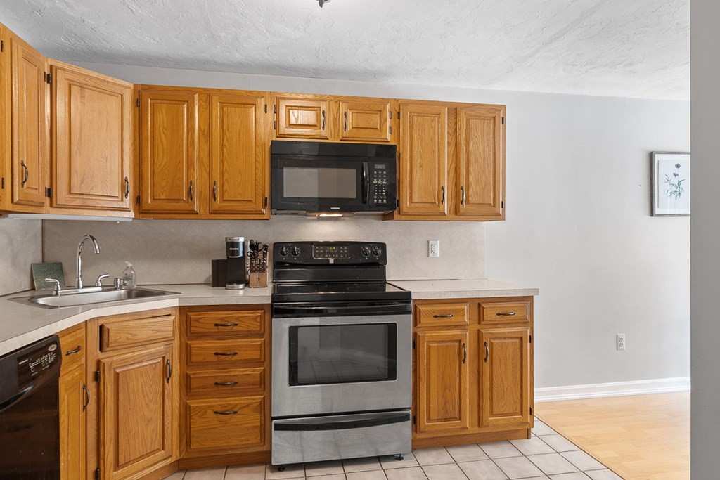 512 Ridgefield Circle, Unit C Clinton, MA 01510 - Photo 5 of 28 a kitchen with granite countertop a stove top oven microwave and cabinets