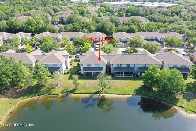 an aerial view of residential houses with outdoor space and parking