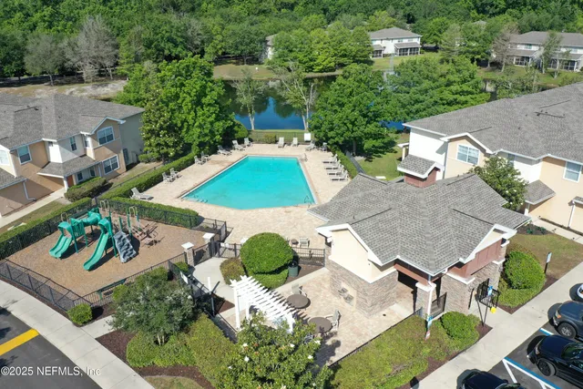 an aerial view of a house with yard and patio