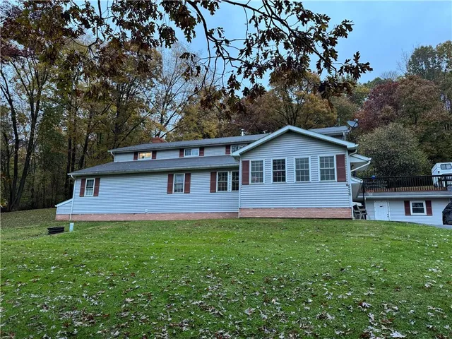 a front view of a house with a yard and trees