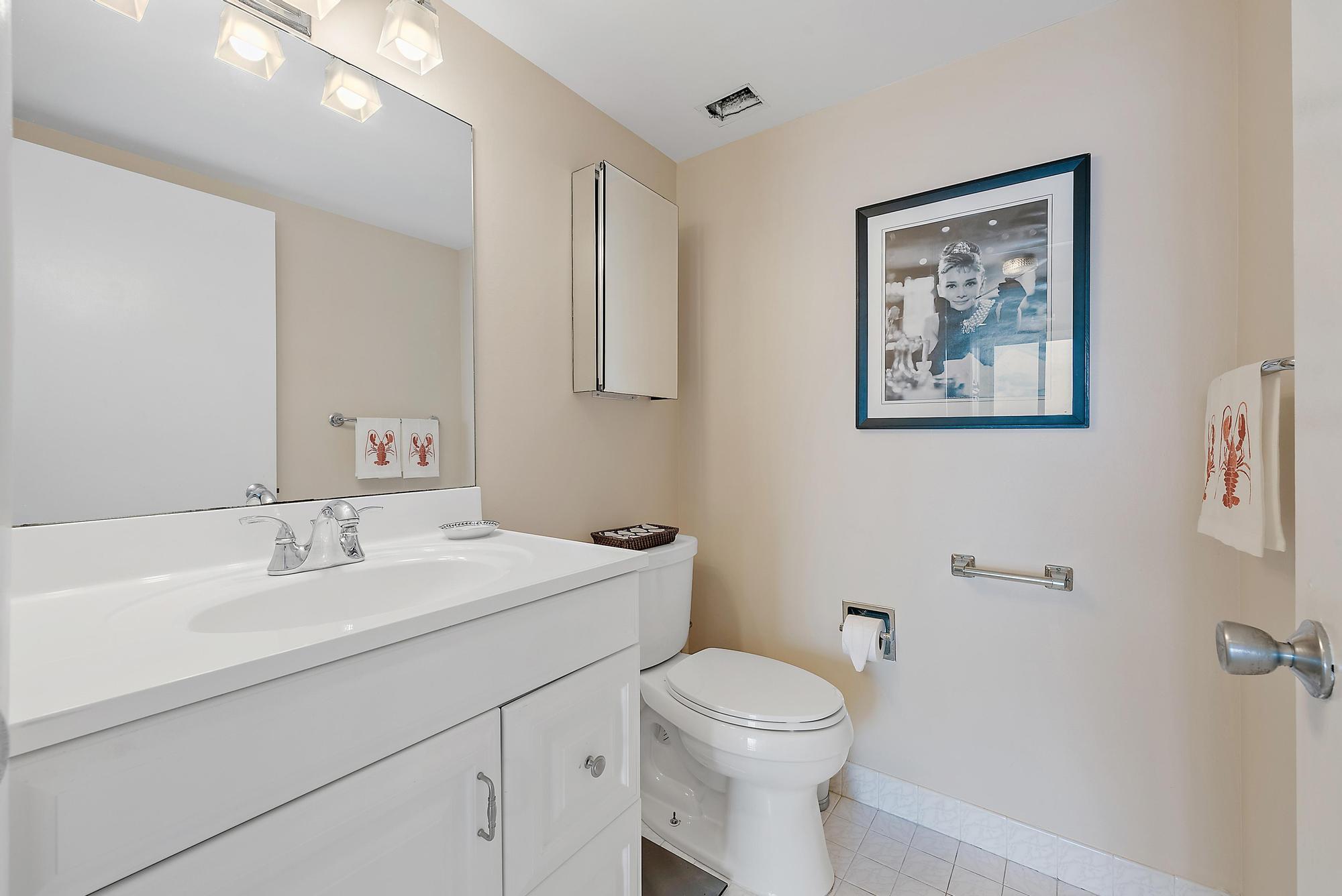 1801 South Flagler Drive, Unit 1206 West Palm Beach, FL 33401 - Photo 8 of 20 a bathroom with a toilet a sink and mirror