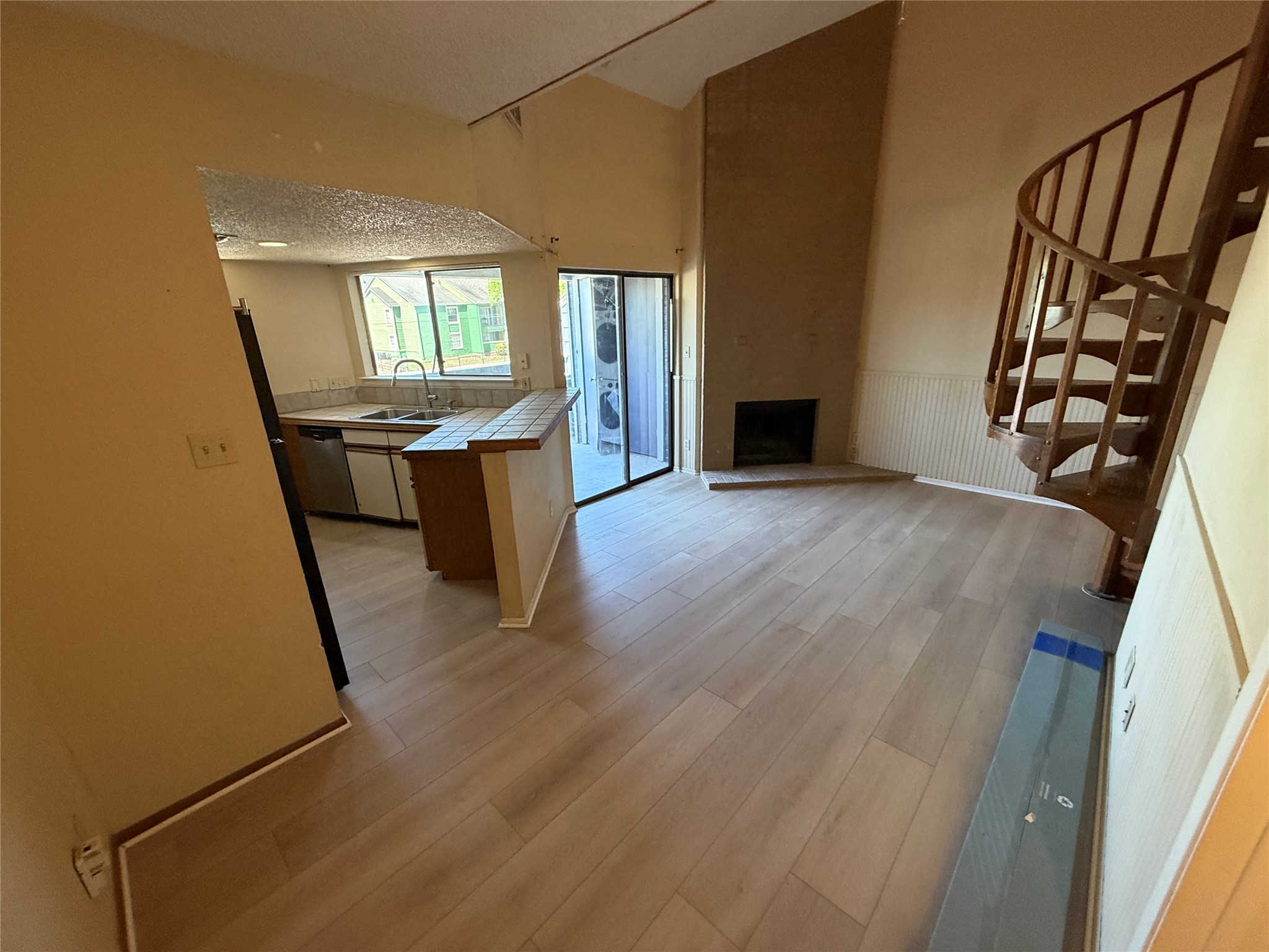 2500 Burleson Road, Unit 221 Austin, TX 78741 - Photo 18 of 18 Kitchen with tile counters, open floor plan, a peninsula, freestanding refrigerator, and light wood-style floors