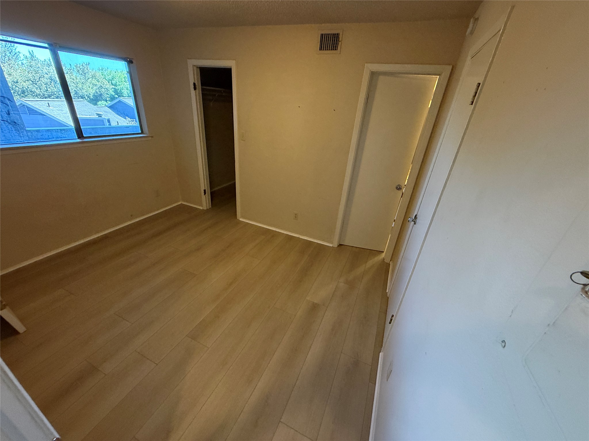 2500 Burleson Road, Unit 221 Austin, TX 78741 - Photo 6 of 18 Unfurnished bedroom featuring light wood-style flooring and a spacious closet