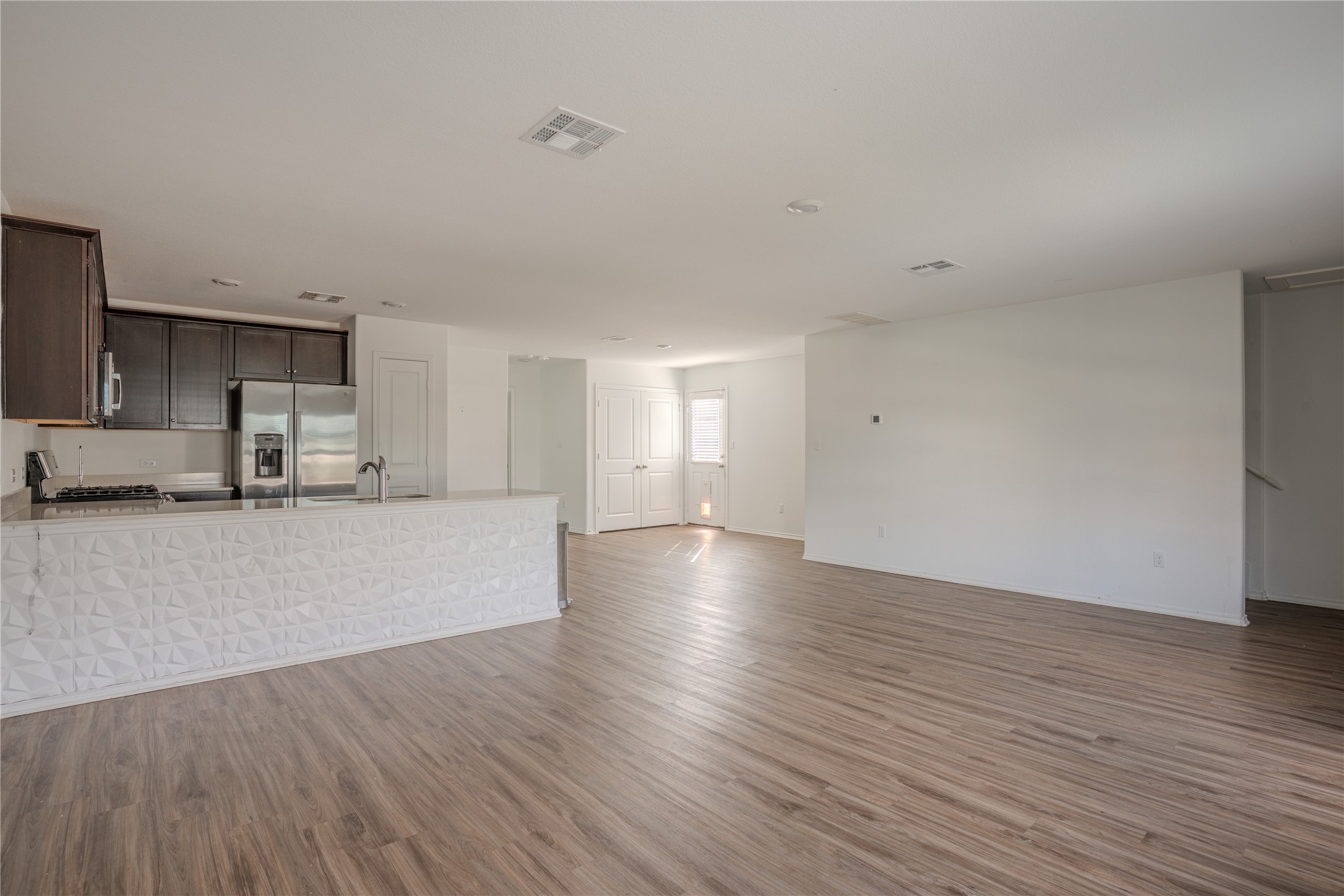 a view of a kitchen with wooden floor and a sink
