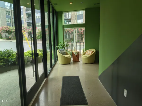 a hallway with two chair and a potted plant