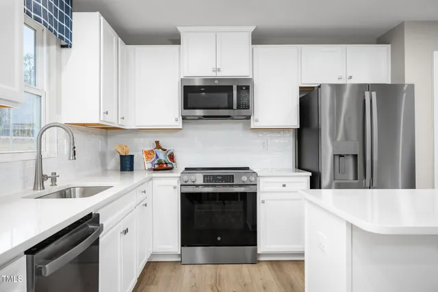 a kitchen with stainless steel appliances granite countertop a stove sink and refrigerator