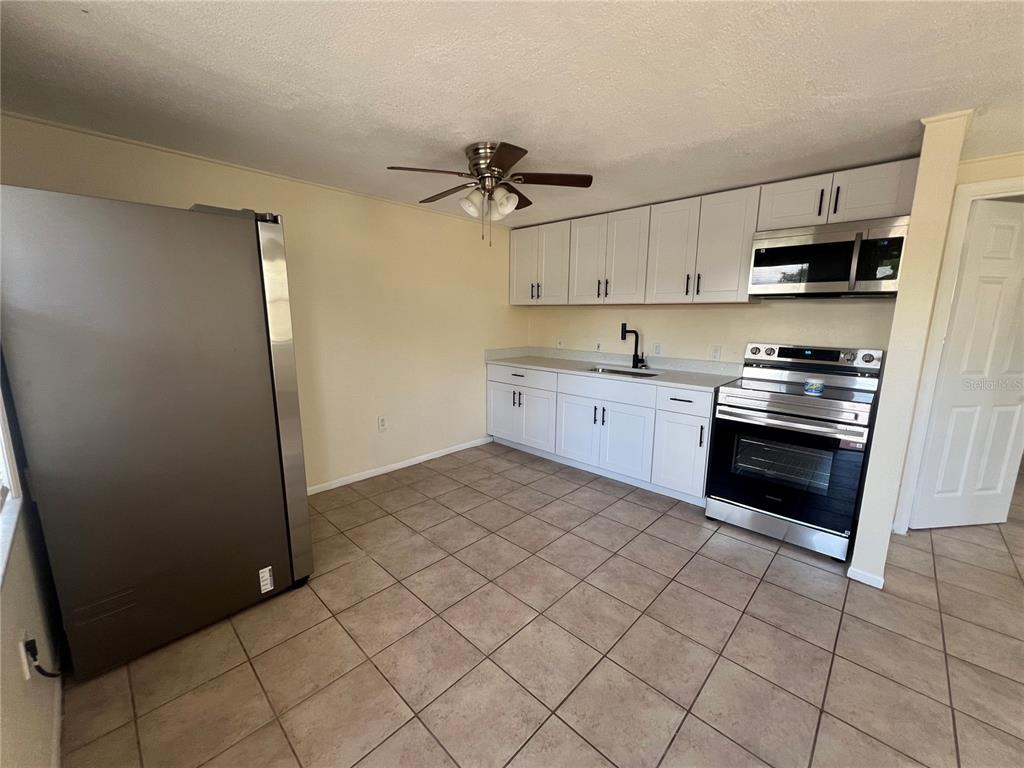 255 Pineapple Street, Unit 3 Englewood, FL 34223 - Photo 7 of 7 a kitchen with stainless steel appliances a stove a sink and a refrigerator