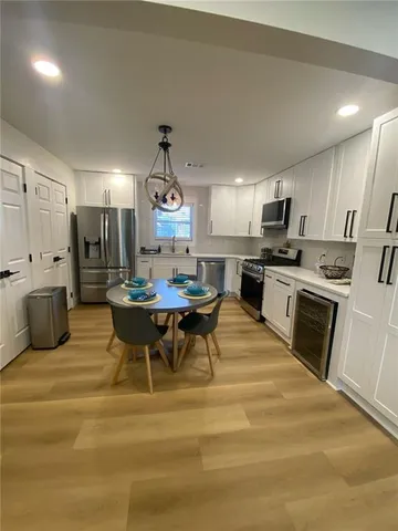 a kitchen with stainless steel appliances kitchen island granite countertop a sink a stove a refrigerator cabinets and chairs