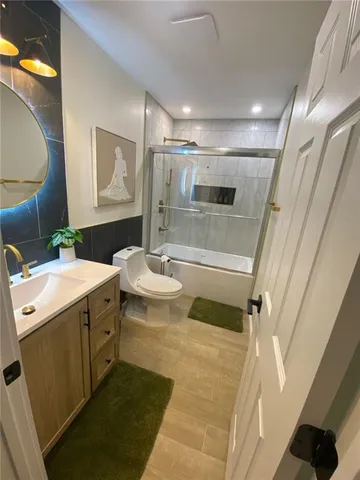 a bathroom with a sink and mirror with bathtub