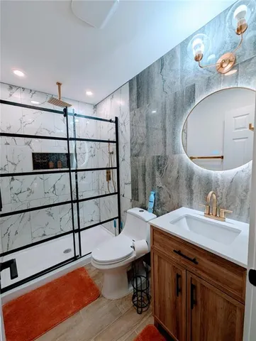a bathroom with a sink toilet vanity and mirror