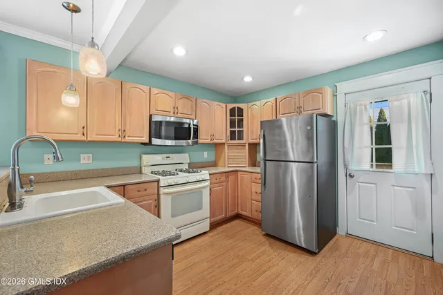a kitchen with stainless steel appliances granite countertop a refrigerator a stove top oven a sink and dishwasher