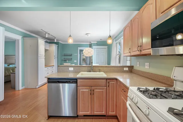 a kitchen with stainless steel appliances granite countertop a sink stove and cabinets