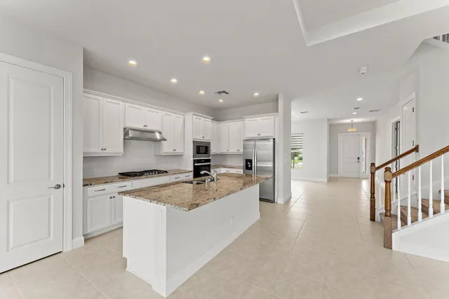 a kitchen with white cabinets and appliances