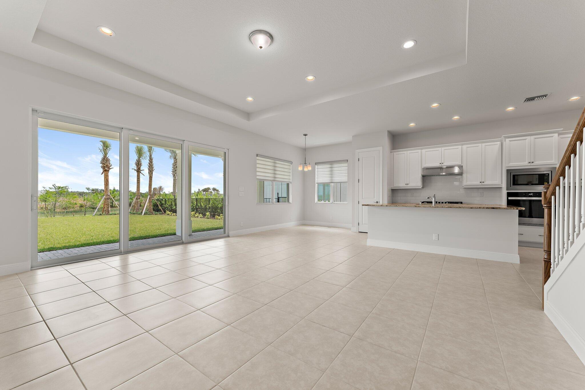 12622 Nautilus Circle Palm Beach Gardens, FL 33412 - Photo 19 of 66 a view of an empty room and kitchen with granite countertop a large window