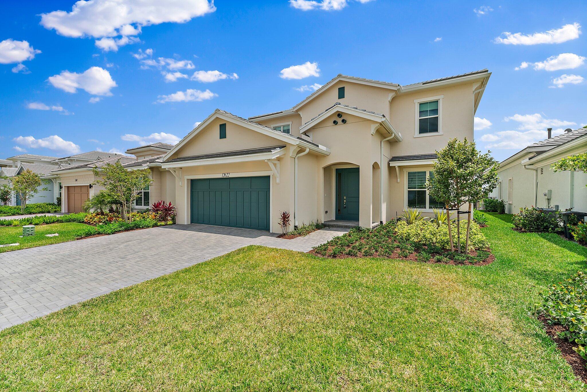 12622 Nautilus Circle Palm Beach Gardens, FL 33412 - Photo 2 of 66 a front view of a house with a yard and garage