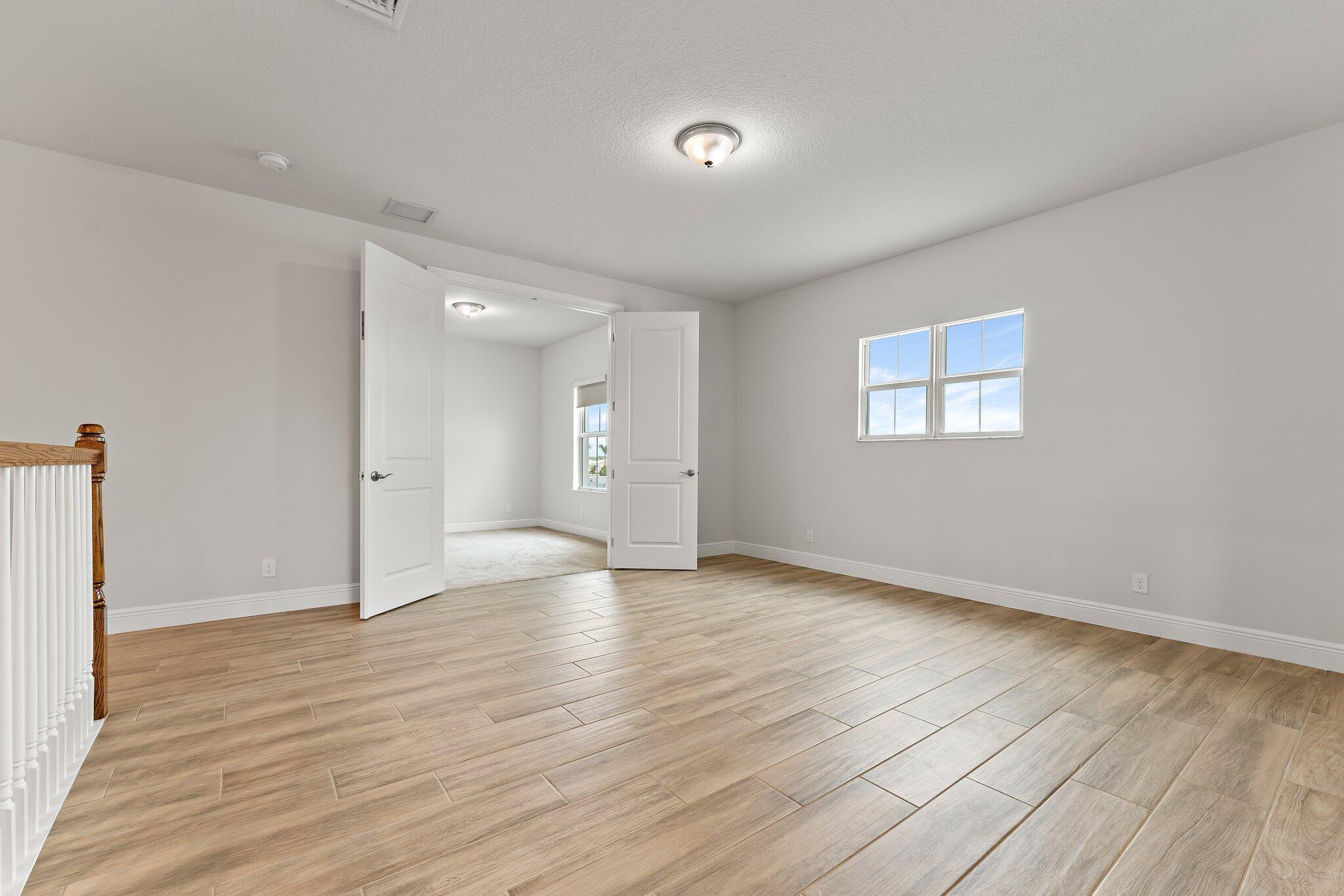12622 Nautilus Circle Palm Beach Gardens, FL 33412 - Photo 25 of 66 a view of an empty room with wooden floor and a window