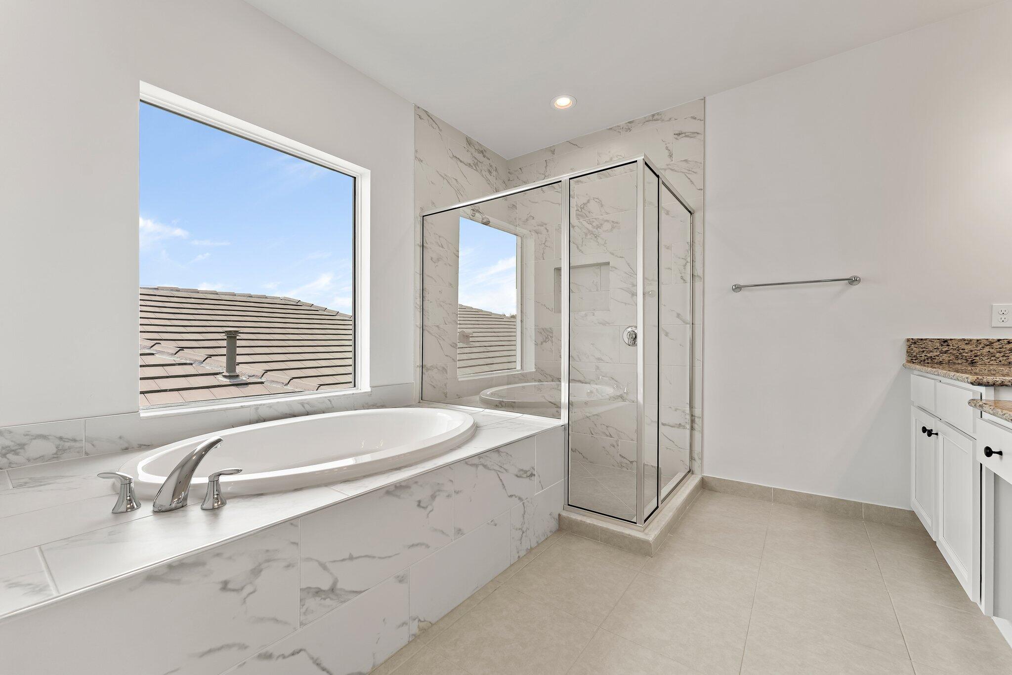 12622 Nautilus Circle Palm Beach Gardens, FL 33412 - Photo 31 of 66 a spacious bathroom with a granite countertop tub sink and mirror