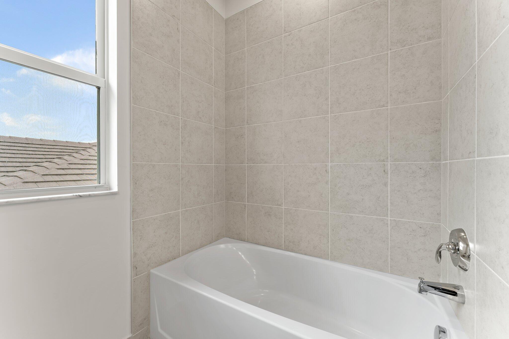 12622 Nautilus Circle Palm Beach Gardens, FL 33412 - Photo 39 of 66 a white bath tub sitting next to a white sink and vanity